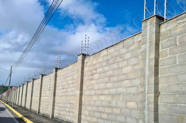 High walls and electric fences to secure houses. Condo security. Protection.